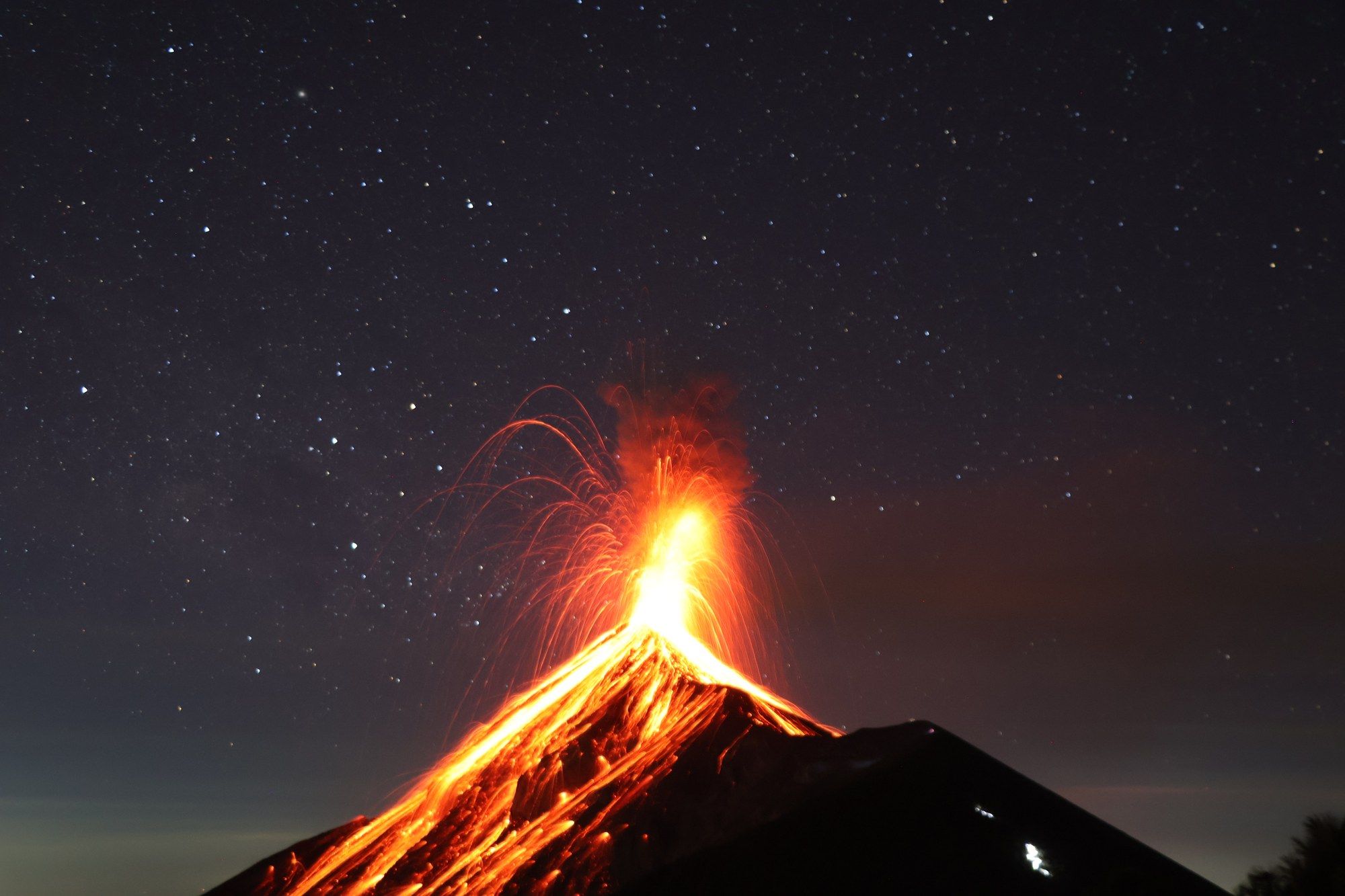 Volcan de Fuego erupting orange against a night sky