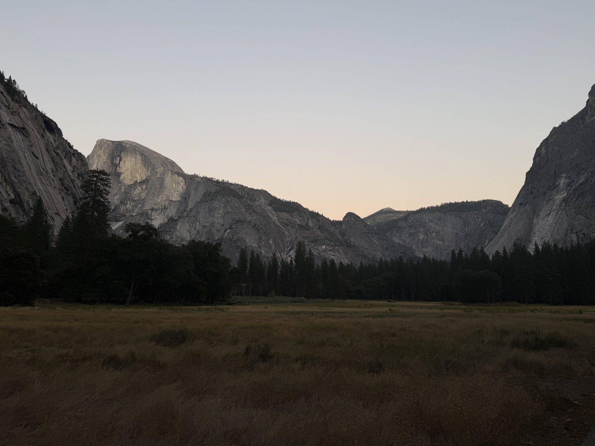 Half Dome above a meadow, lit by the last light of the day