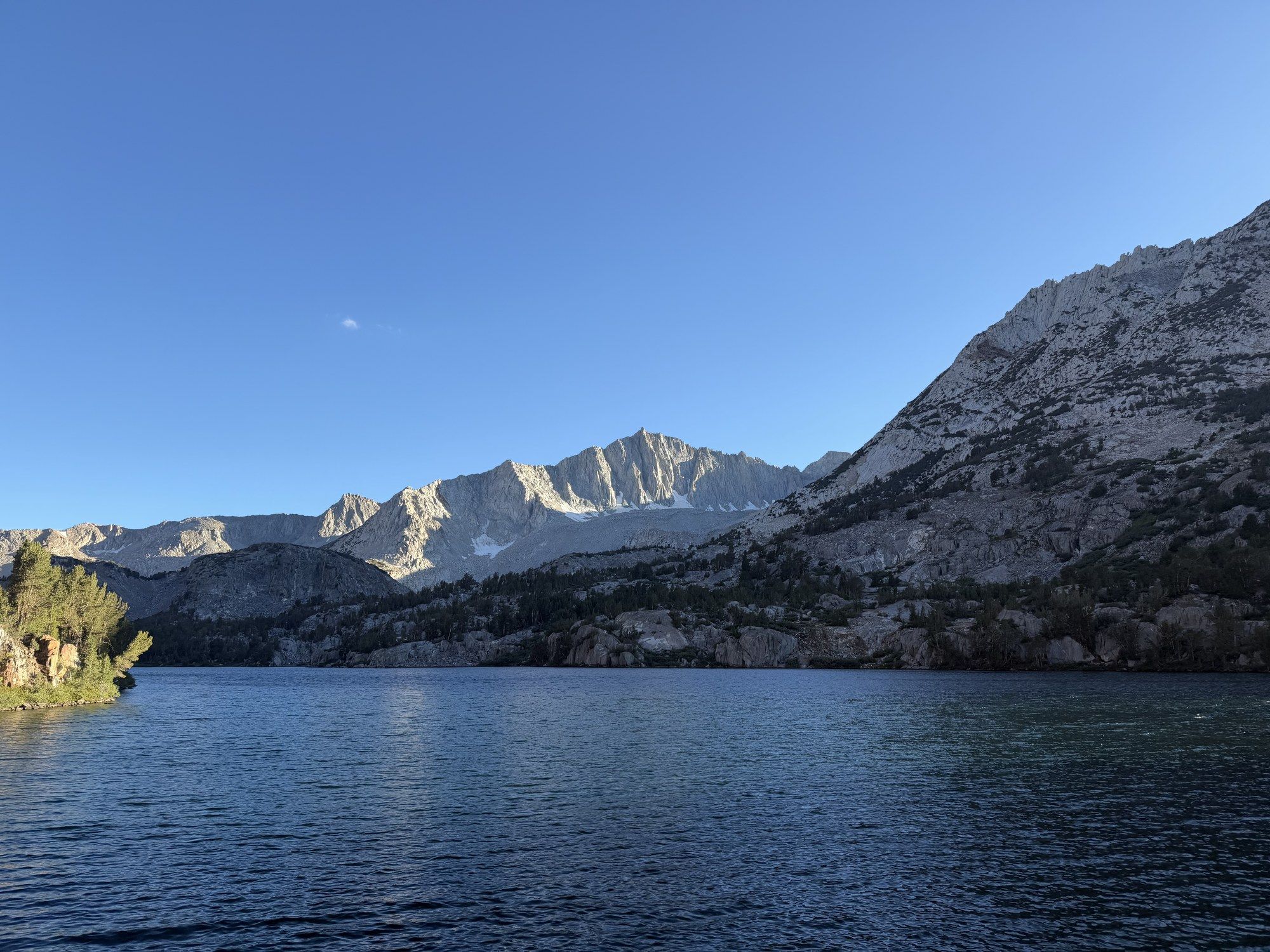 A deep blue alpine lake held in bare granite