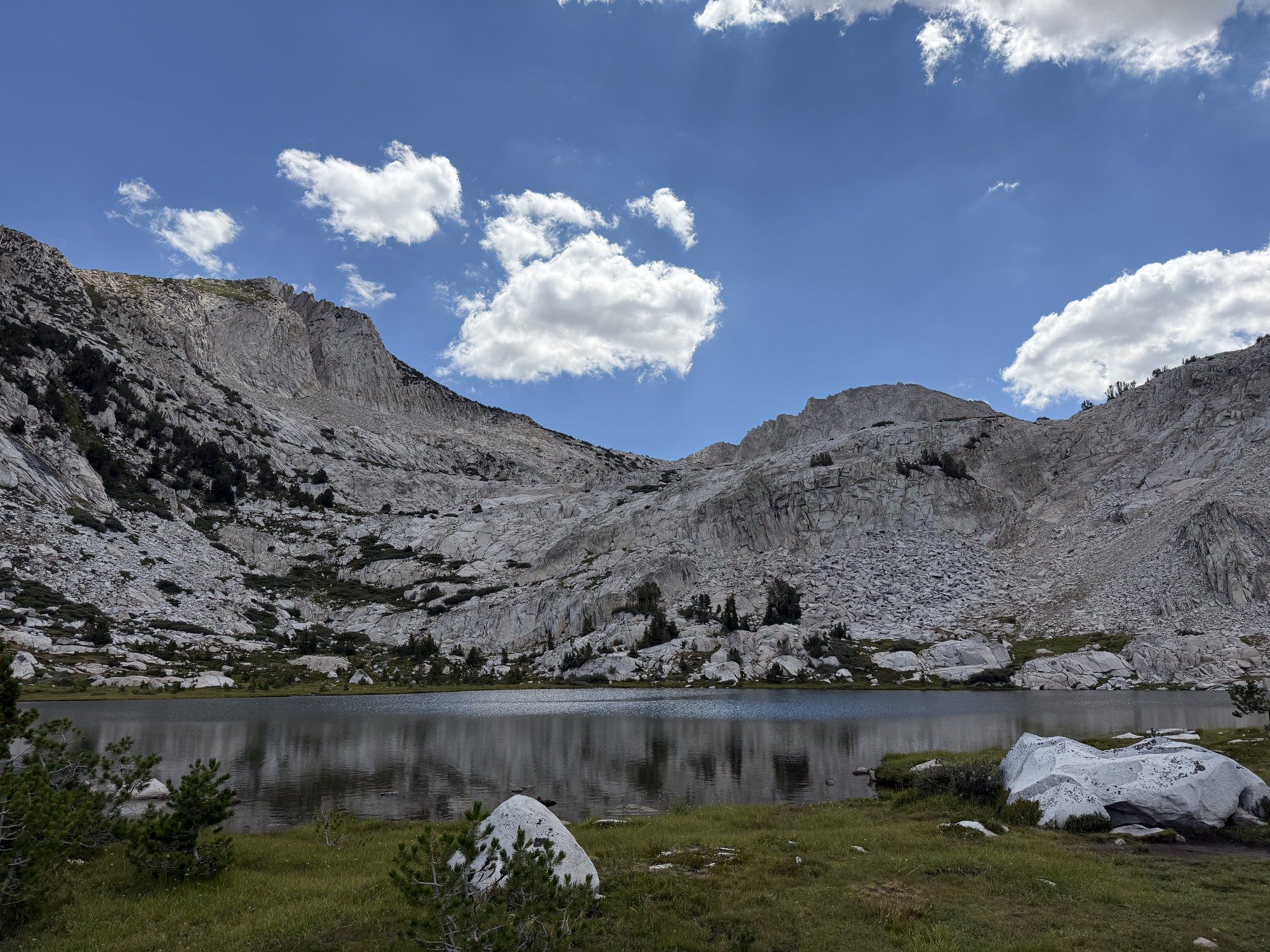 An alpine lake ringed by granite slabs high in the Sierra Nevada