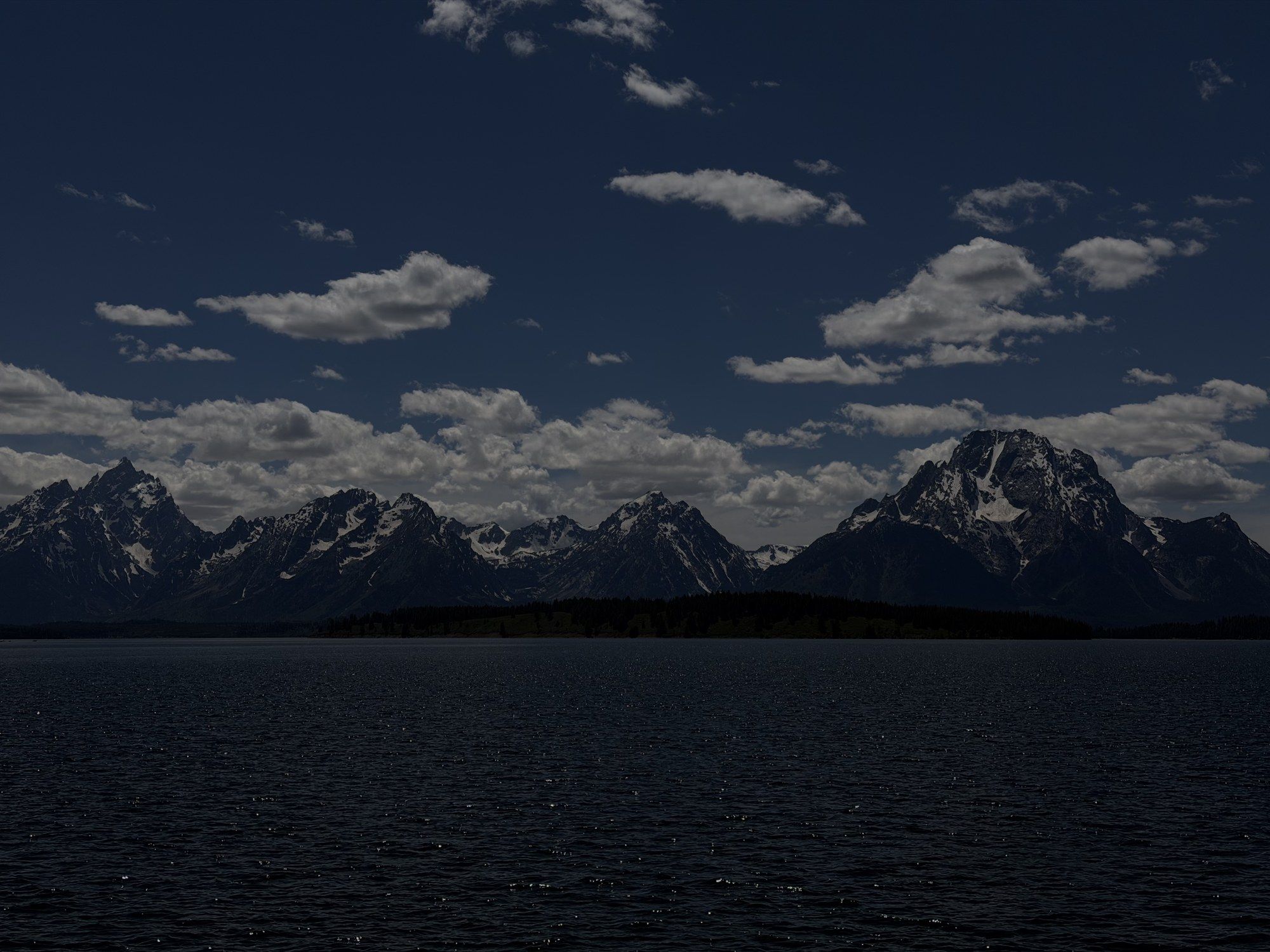 The Teton range across a dark lake at night