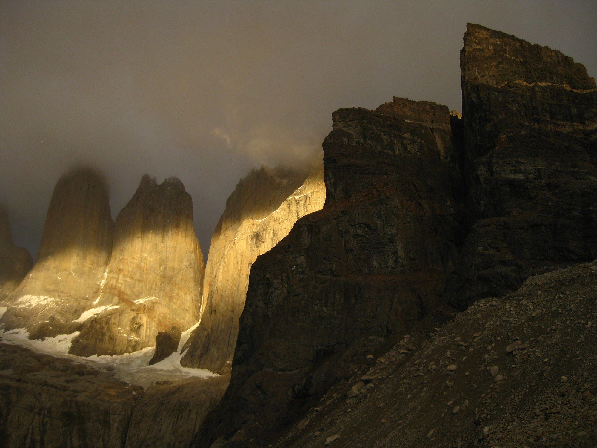 A shaft of gold light striking the Torres del Paine spires