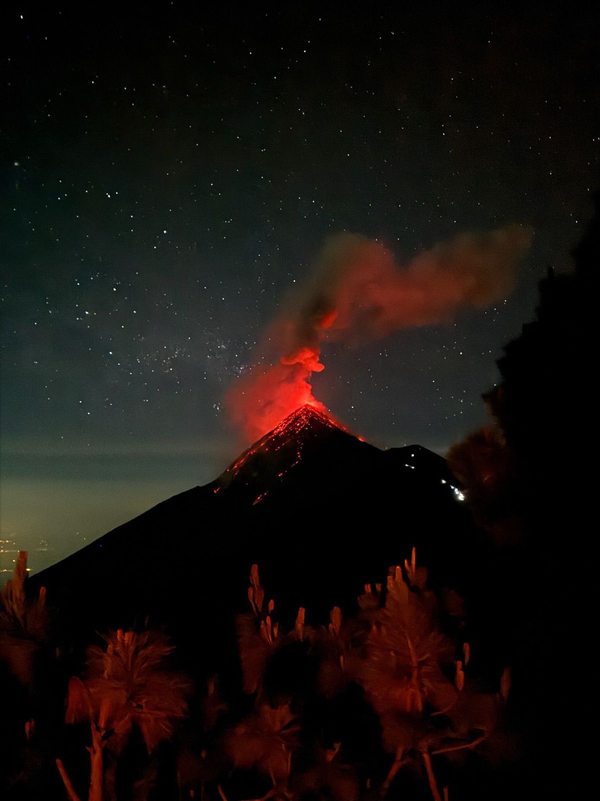 Fuego's volcanic cone glowing red under a starry night