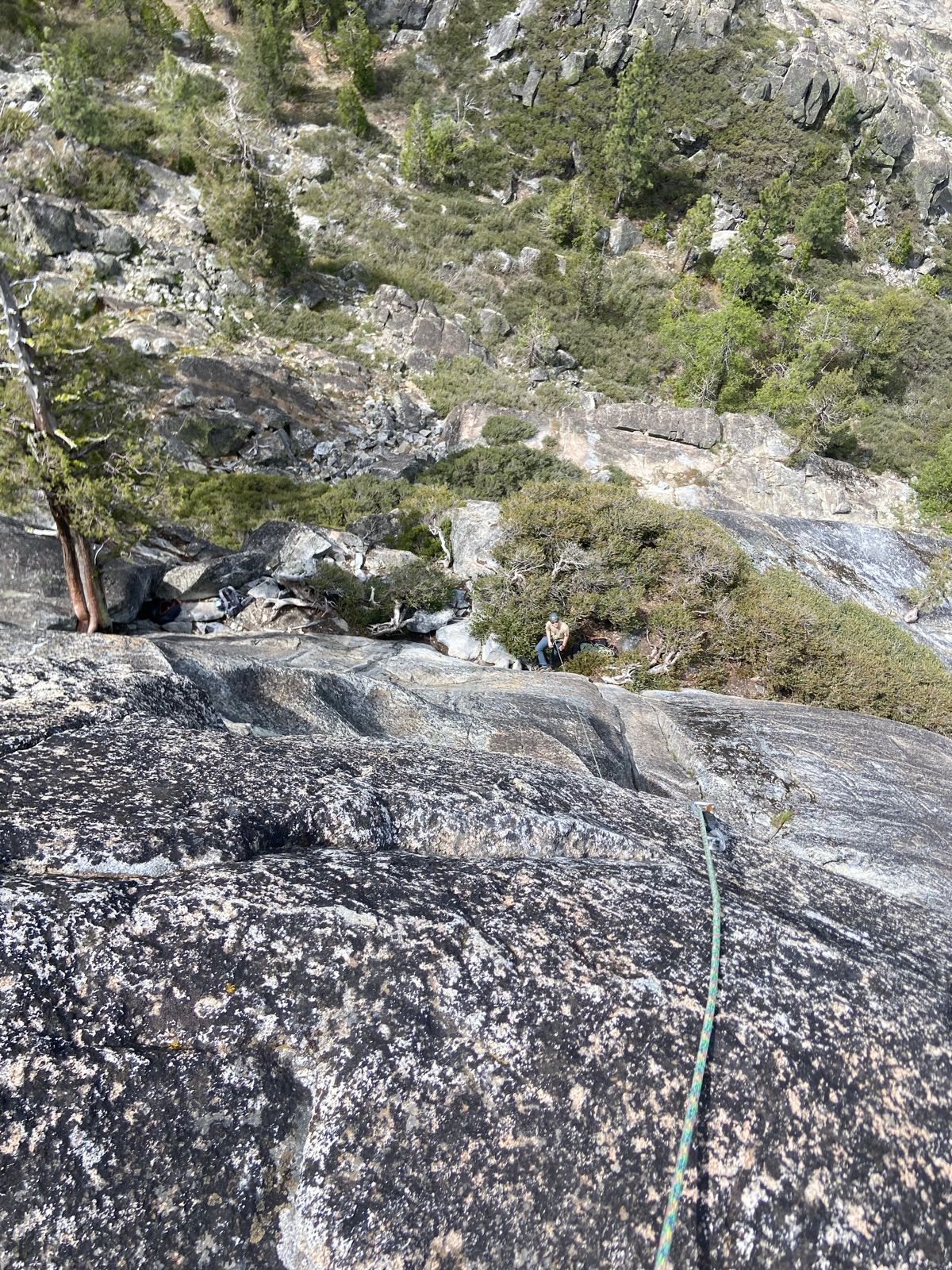 Climber on a rope viewed from above on gray granite