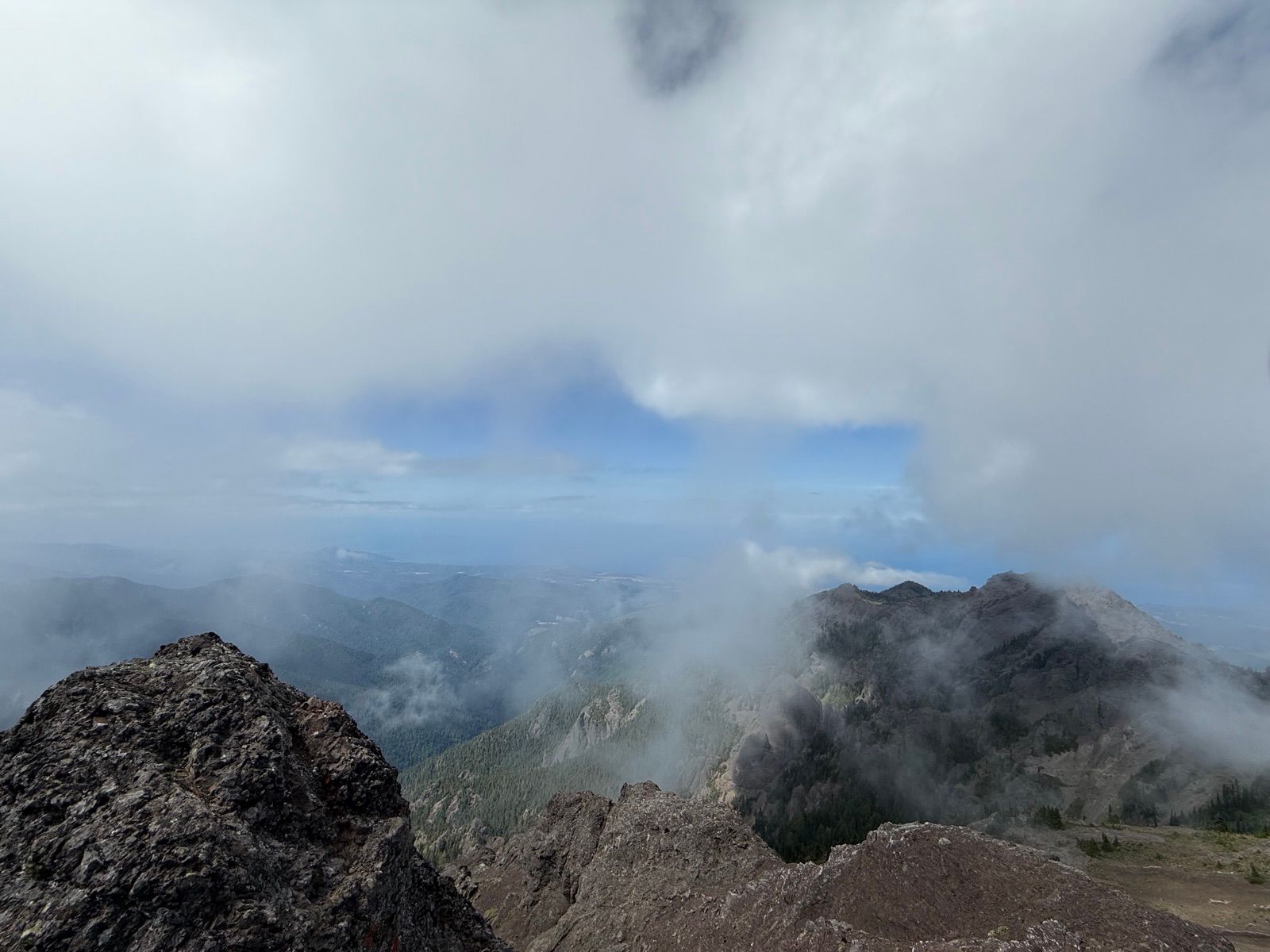 Rocky summit disappearing into shifting cloud