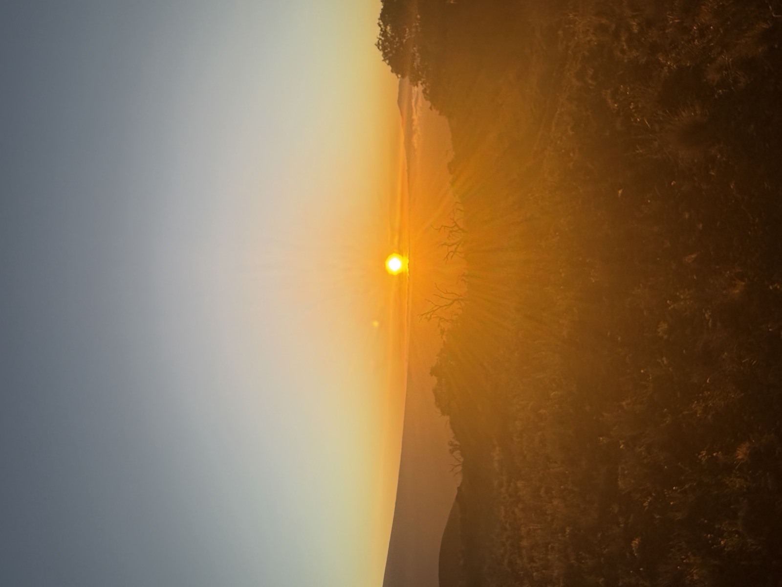 Sun setting over rolling volcanic slopes