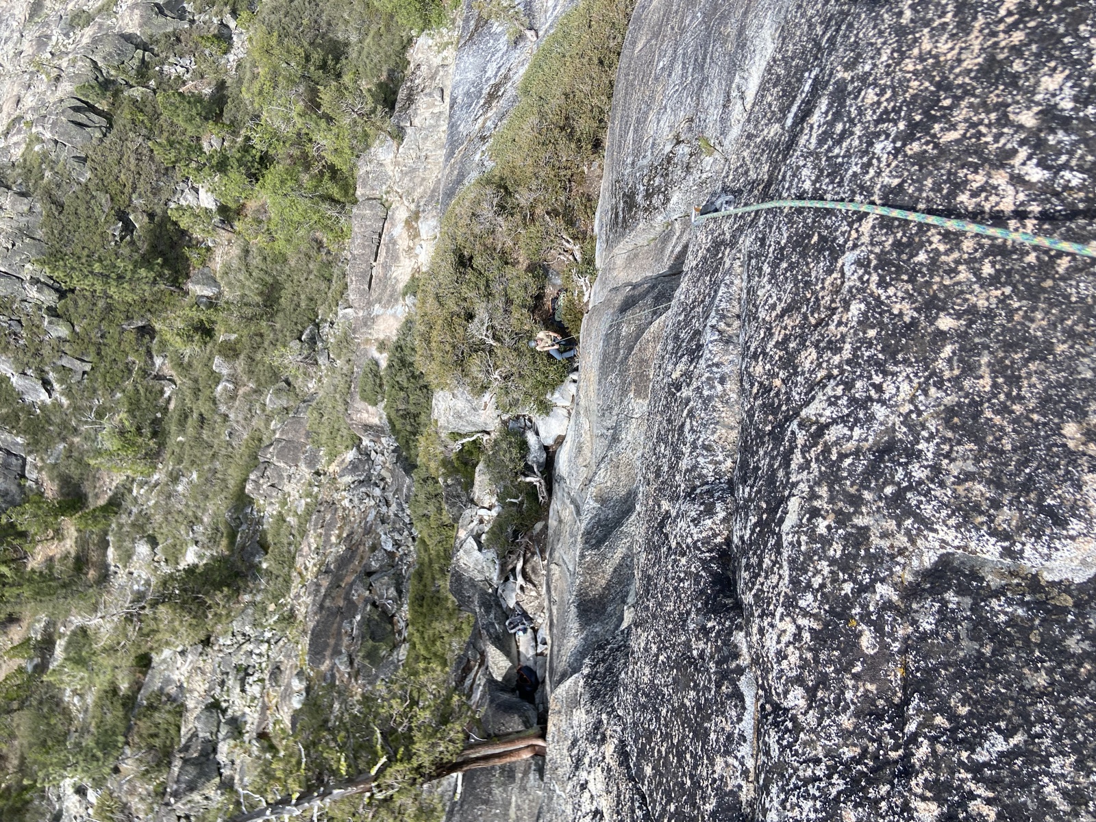 Climber on a rope viewed from above on gray granite