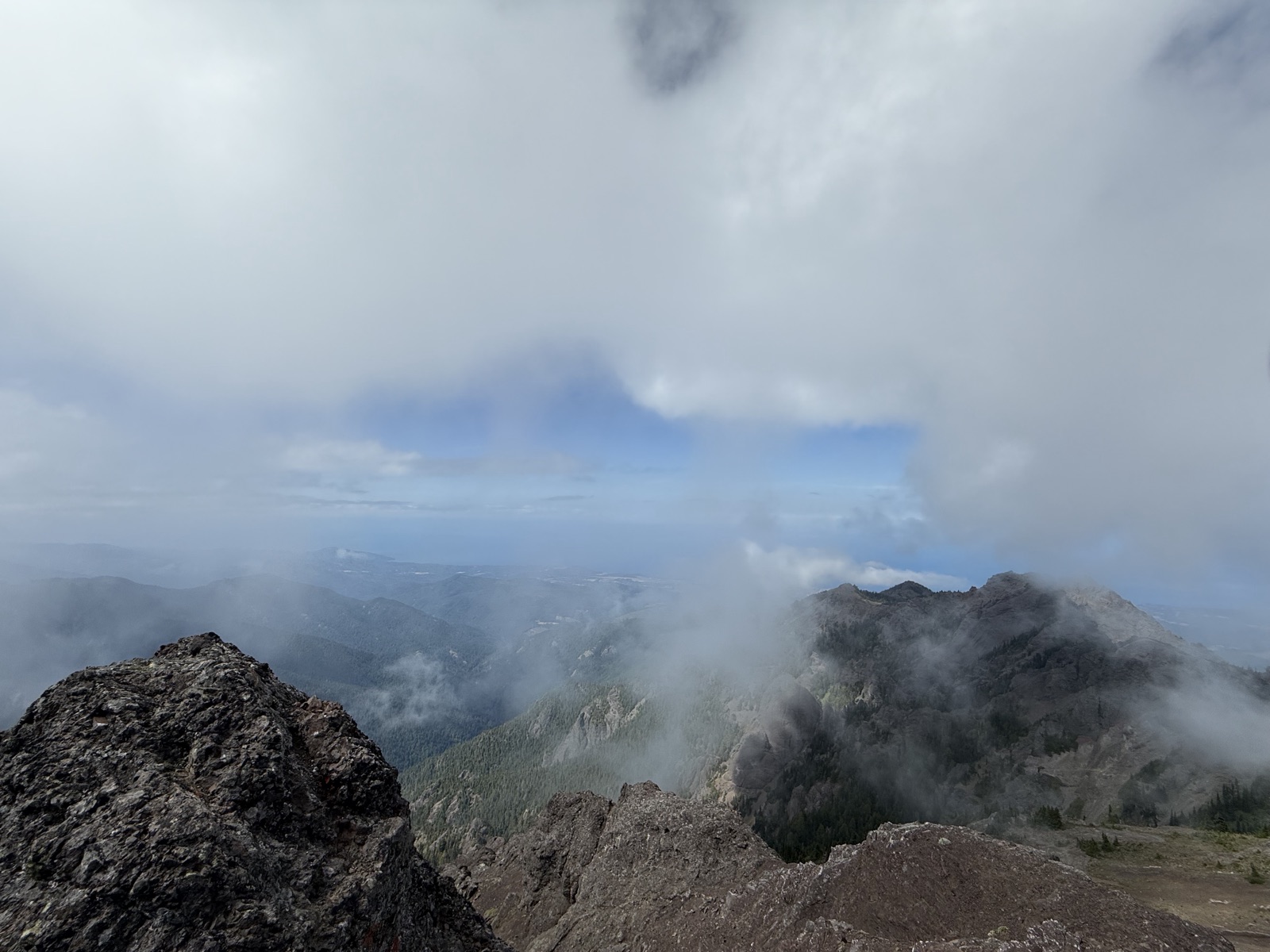 Rocky summit disappearing into shifting cloud
