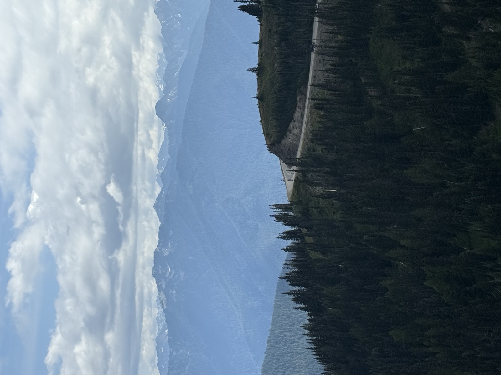 Road crossing an alpine ridge beneath broken clouds