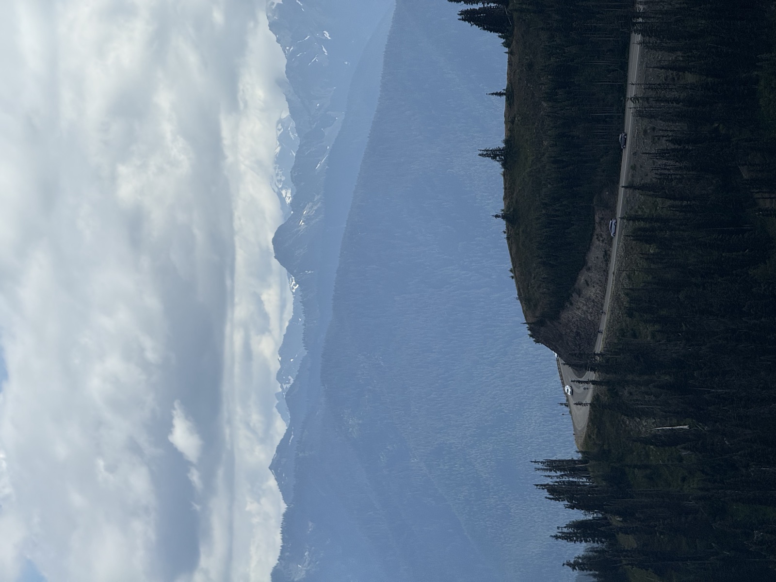 Cloudy Cascade peaks beyond a dark forested ridgeline